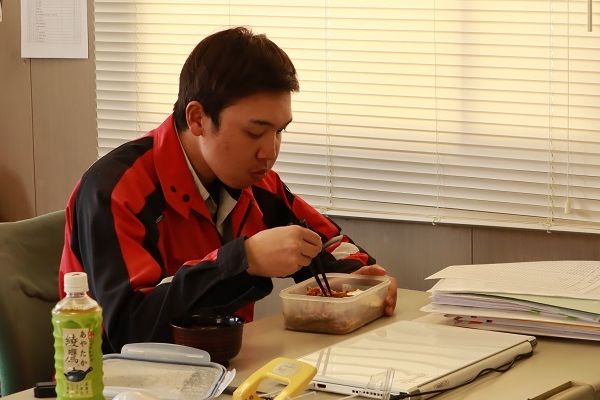 弁当を食べる建設技術者